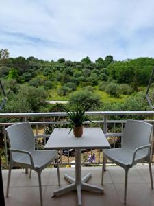 uma mesa e 2 cadeiras numa varanda com vista em Evridiki Apartments em Mesongi