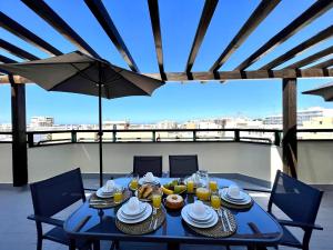 una mesa azul con comida y bebidas en el balcón en Faro Rising by Homing, en Faro