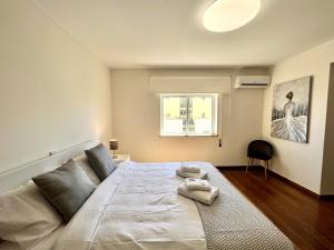 1 dormitorio con 1 cama grande y toallas. en Faro Rising by Homing, en Faro