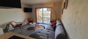 een woonkamer met een bank en een tafel bij Duplex Fréjus Plage, 2' plage et commerces in Fréjus