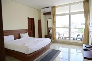 a bedroom with a bed and a large window at KCG Residency in Mysore
