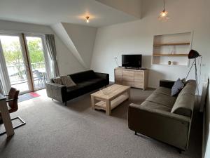 un soggiorno con un divano e una TV di Penthouse DeLuxe a Oostkapelle