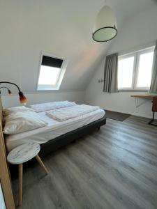 una camera da letto con un letto, un tavolo e finestre di Penthouse DeLuxe a Oostkapelle