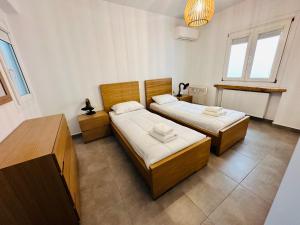 two beds in a room with two windows at Seaview & Jacuzzi Villa Sea View in Mikonos