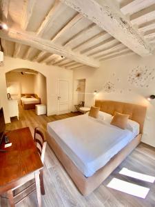 a large bedroom with a large bed and a table at Casa Ambra in Cortona