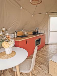 a kitchen in a tent with a table and chairs at Biała Czapla Glamping z balią nad jeziorem czorsztyńskim in Maniowy