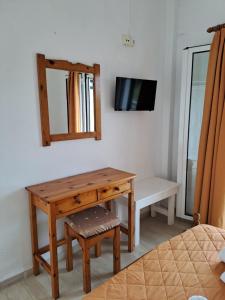 Habitación con mesa de madera y espejo. en Evridiki Apartments, en Mesongi