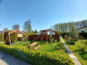 un pequeño jardín con parque infantil y columpio en domek Lawendowy na wiejskiej en Lubiatowo