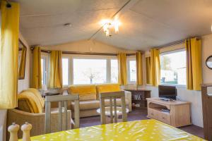a living room with a couch and a table at Great 6 Berth Caravan For Hire At Southview Holiday Park Ref 33006m in Skegness