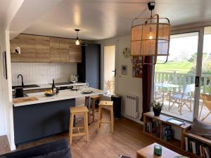 a kitchen and a living room with a table and chairs at La terrasse du golf in Port-en-Bessin-Huppain