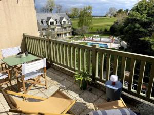 d'un balcon avec une table, des chaises et une piscine. dans l'établissement La terrasse du golf, à Port-en-Bessin-Huppain
