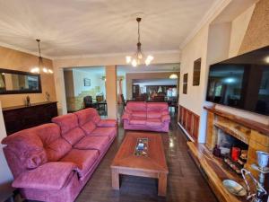 a living room with two pink couches and a fireplace at Night Flower Villa in Kato Korakiana