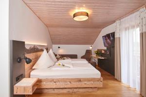 a bedroom with a large bed and a wooden ceiling at Landgasthof Zum Sägwirt in Eggstätt