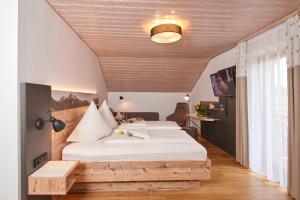 ein Schlafzimmer mit einem großen Bett und einer Holzdecke in der Unterkunft Landgasthof Zum Sägwirt in Eggstätt