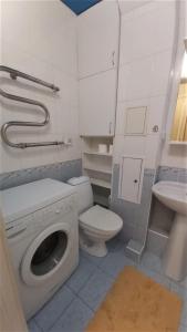 a bathroom with a washing machine and a toilet at Апартаменти поруч з метро Лівобережна in Kyiv