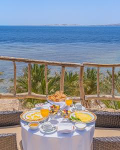 una mesa con platos de comida en la playa en Tamra Beach Resort, en Sharm El Sheikh