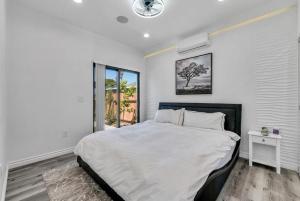 a white bedroom with a large bed and a window at Luxury 2 bedroom villa in Huntington Beach