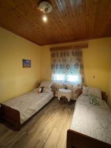 a bedroom with two beds and a wooden ceiling at Carefree Dreams : Cottage in Flogita Chalkidiki in Flogita