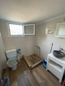 La salle de bains est pourvue de toilettes et d'un lavabo. dans l'établissement Carefree Dreams : Cottage in Flogita Chalkidiki, à Flogita