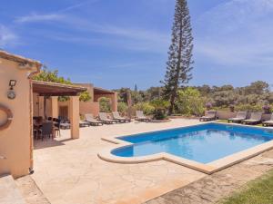 a pool in a yard with chairs and a tree at Finca Torrent Des Jai in Cala Mondrago