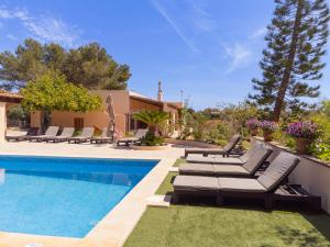 a villa with a swimming pool and lounge chairs at Finca Torrent Des Jai in Cala Mondrago