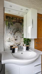 bagno con lavandino bianco e specchio di Ferienwohnung Xandl a Kaibing