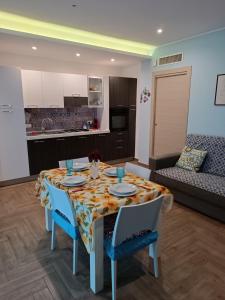 mesa de comedor con sillas y cocina en Casa Azzurra, en Giardini Naxos