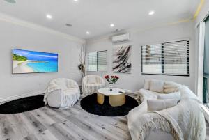 a living room with white furniture and a table at Luxury 2 bedroom villa in Huntington Beach