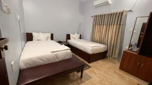 - une petite chambre avec 2 lits et un miroir dans l'établissement PROVINCE FIVE HOTEL, à Siddharthanagar