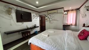 sypialnia z białym łóżkiem i telewizorem w obiekcie Domon Riverside Hotel w mieście Vang Vieng