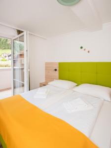 a bedroom with a large bed with yellow and white sheets at Fischerhof Glinzner Hotel-Restaurant-Camping in Afritz