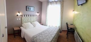 a bedroom with a white bed and a window at Hôtel Saint Michel in Digne-les-Bains