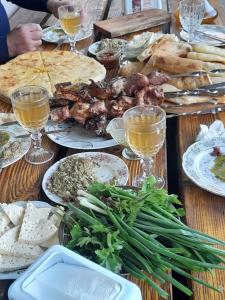 una mesa con platos de comida y copas de vino en gogi, en Tskaltubo