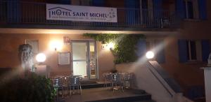 a restaurant with chairs and a sign on a building at Hôtel Saint Michel in Digne-les-Bains