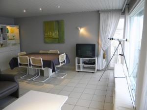 sala de estar con mesa y TV en Atlantic 0635, en Koksijde