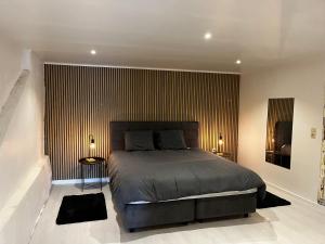 a bedroom with a large bed and a striped wall at Le Repaire d'Alfred in Stavelot