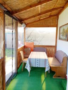 - une table et des chaises dans une véranda dans l'établissement Ultima Frontiera- Dunavatu de Jos, à Dunavăţu de Jos
