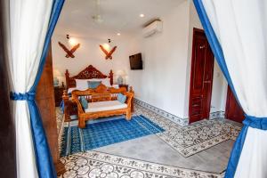 1 dormitorio con cama y ventana en Khmer Surin Boutique Guesthouse, en Phnom Penh