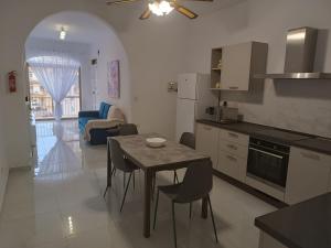 uma cozinha e sala de jantar com mesa e cadeiras em Seagull Flats em Marsalforn