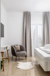 a bedroom with a bed and a chair and a window at Luxury Apartments Klara in Split