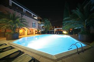 a large swimming pool at night with chairs around it at Hotel La Paül in Sirmione