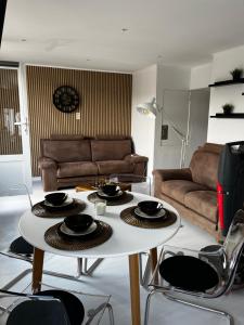 a living room with a white table and chairs at Le Repaire d'Alfred in Stavelot