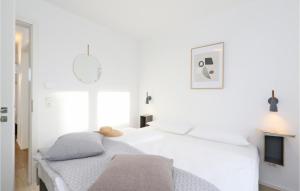 ein weißes Schlafzimmer mit einem Bett und einem Fernseher in der Unterkunft Cozy Apartment In Lembruchdümmer See in Lembruch