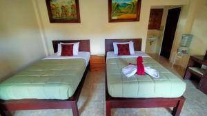 two beds in a room with two beds with bows at Happy Inn 2 in Ubud