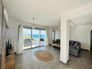 a living room with a couch and a view of the ocean at Seaview & Jacuzzi Villa Sea View in Mikonos