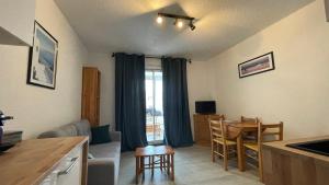 Una cocina y una sala de estar con mesa y sillas. en Hispaniola, avec vue sur la marina et parking privé, en Saint-Cyprien