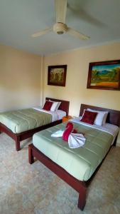 2 Betten in einem Zimmer mit einer Decke in der Unterkunft Happy Inn 2 in Ubud
