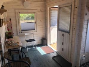 een kleine kamer met een deur en een raam bij WOMOCAMP Holzhütte 2 in Saulkrasti