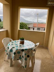 una mesa y sillas en un balcón con ventana en Bayekou, en Paceco