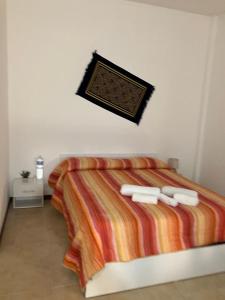 1 dormitorio con 1 cama y 2 toallas blancas en Bayekou, en Paceco